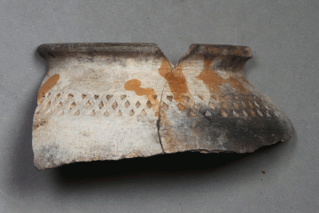 Fragment eines Topfes mit Wackelboden, Rotbemalung und Rädchendekor von der Burg Wahlmich. Unterfranken, um 1250