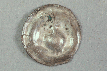 Brakteat mit Reichsapfel (?) aus Silber von der Burg Mömbris, Süddeutschland, zweite Hälfte 13. Jh., Fd.-Nr. 201, H. 1,4 cm, Br. 1,45 cm