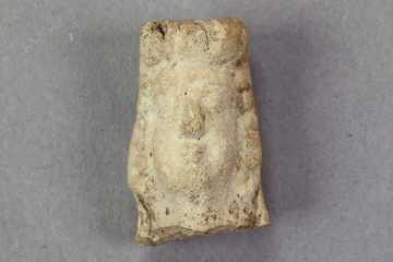 Fragment eines Pfeifentonfigürchens aus Pfeifenton von der Burg Mömbris, Rhein-Main-Raum, Anfang 14. Jh., Fd.-Nr. 443, H. 2,73 cm, Br. 1,75 cm