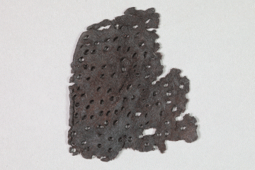 Fragment des Oberleders eines Schuhs mit zahlreichen Durchlochungen, Fd.-Nr. 285a, um 1400, H. 7,6 cm, Br. 6,6 cm