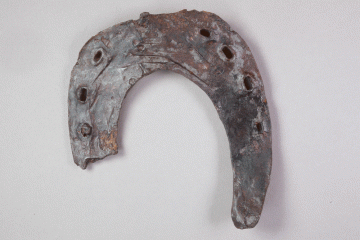 Fragment eines Hufeisens aus Eisen von der Burg Mömbris, Unterfranken, Ende 14. Jahrhundert, Fd.-Nr. 452, H. 12,9 cm, Br. 11,8 cm